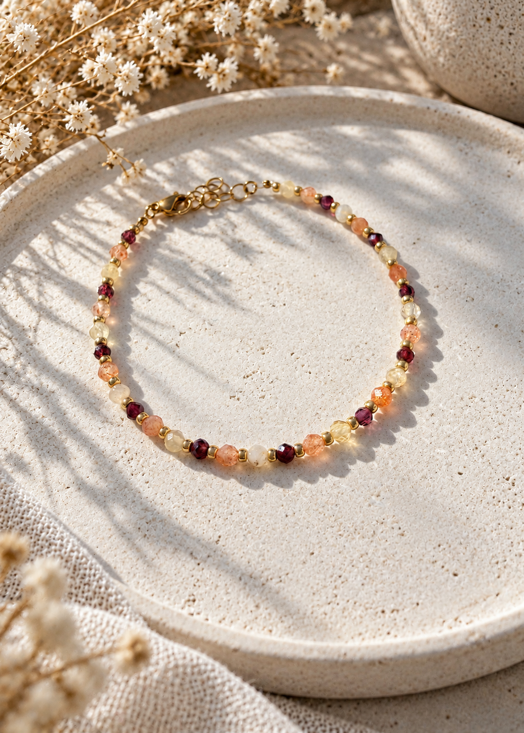 Bracelet composé de 3 pierres grenat, pierre de soleil, citrine et de perles en verre dorées