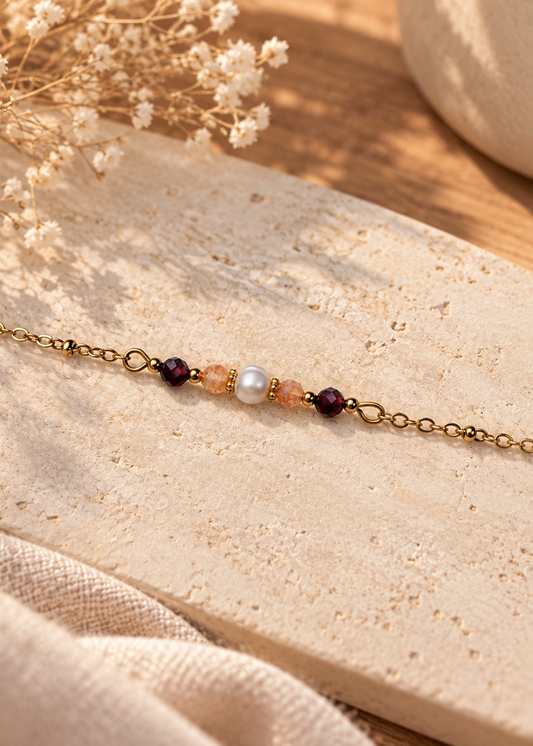 Bracelet minimaliste composé d’une perle naturelle, de pierres naturelles grenat et pierre de soleil